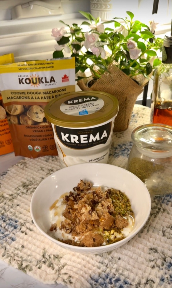 A yogurt bowl topped with baklava crumble, styled with Koukla and Krema products